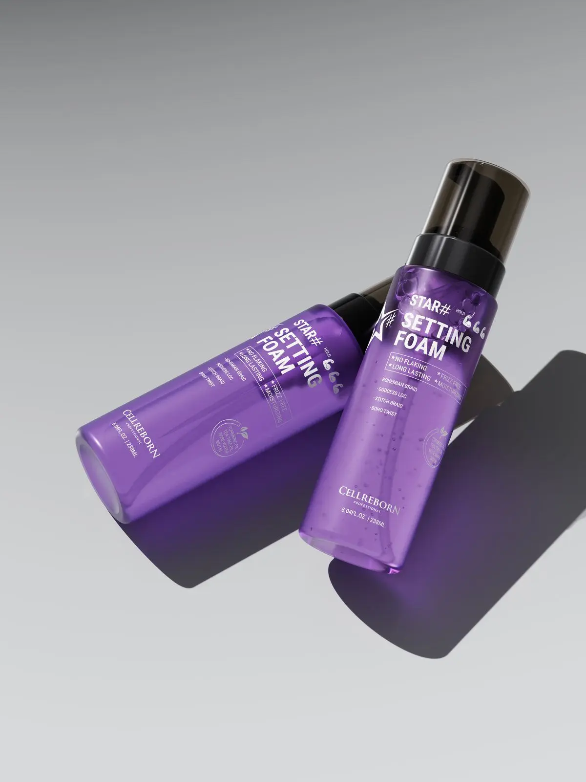 Two violet CELLREBORN STAR# Setting Foam bottles lying crossed on a grey surface with violet light